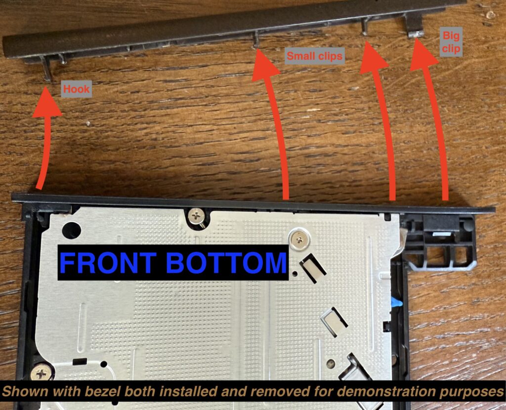 A view of the tray upside down, showing how to lever off the bezel and its 4 clips