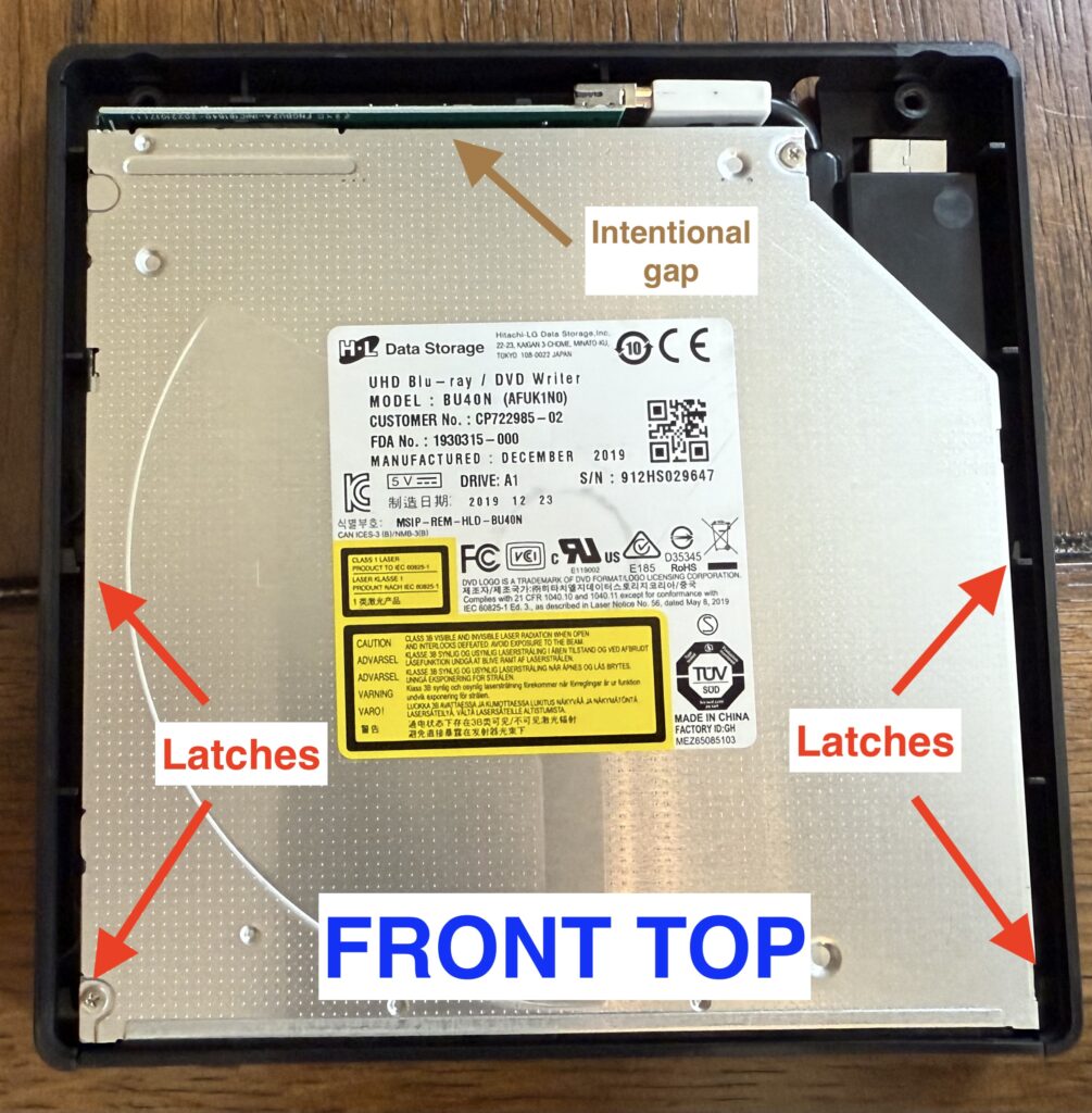 a picture of the inside of the enclosure with the drive installed, showing 4 latches, 2 on either side, near the opening